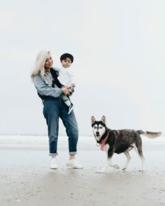 Mother, child, dog on beach