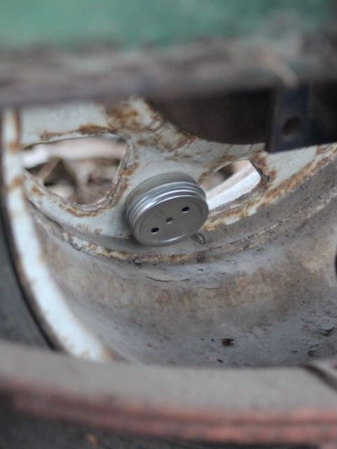 Scent tin hidden on a vehicle wheel during K9 Nose Work training